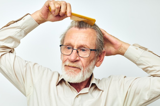 Uomo anziano che pettina i capelli in studio