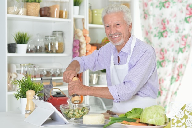 Uomo anziano che prepara la cena in cucina