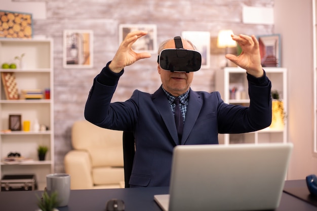Uomo anziano che sperimenta per la prima volta la nuova tecnologia della realtà virtuale a casa sua