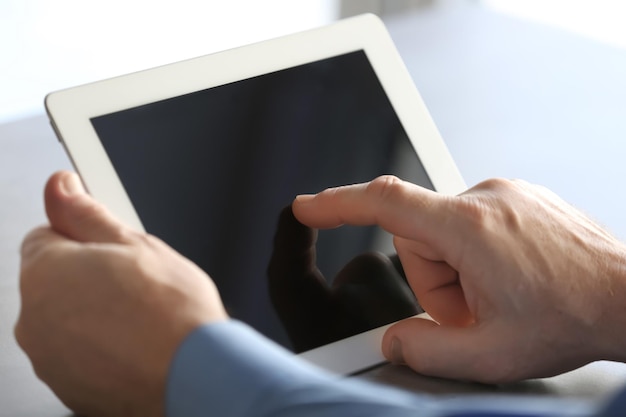 Uomo anziano che utilizza tablet sul tavolo