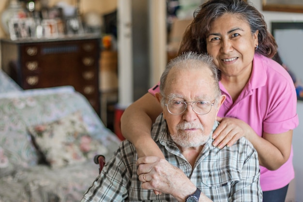 Uomo anziano con il loro caregiver a casa. Concetto di assistenza sanitaria per anziani, disabili