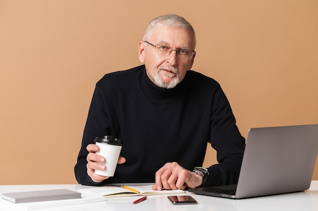 Uomo anziano con il ritratto del computer portatile