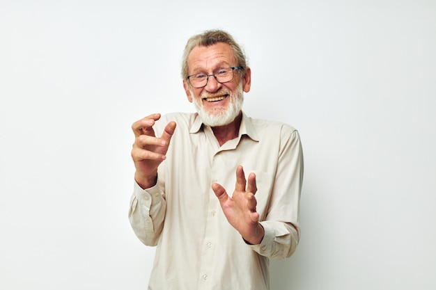 Uomo anziano con la barba grigia in una camicia e occhiali sfondo chiaro