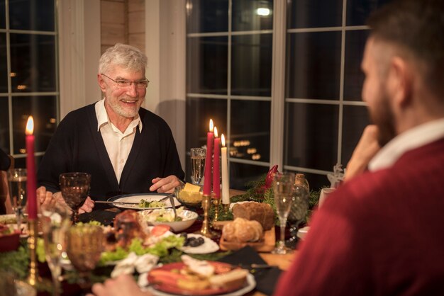 Uomo anziano con suo figlio a una cena di Natale