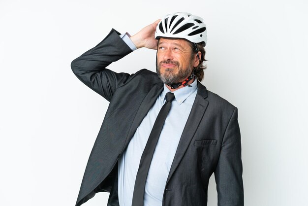 Uomo anziano d'affari con un casco da bici isolato su sfondo bianco con dubbi e con espressione facciale confusa