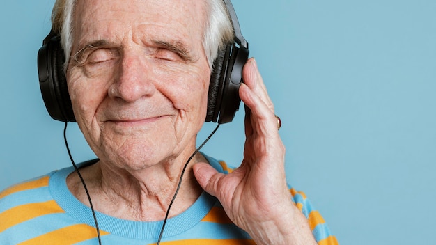 Uomo anziano felice che ascolta musica con le cuffie