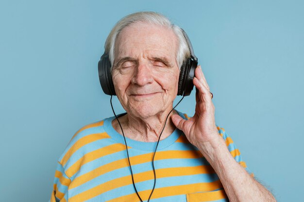 Uomo anziano felice che ascolta musica con le cuffie