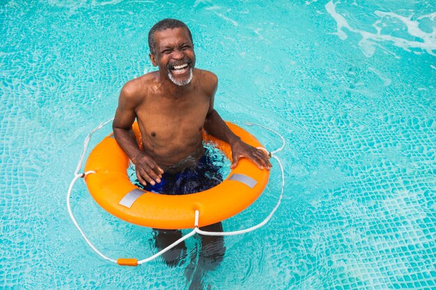 Uomo anziano felice che fa festa in piscina