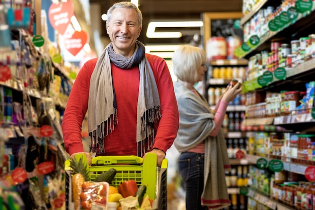 Uomo anziano felice che gode dello shopping con sua moglie