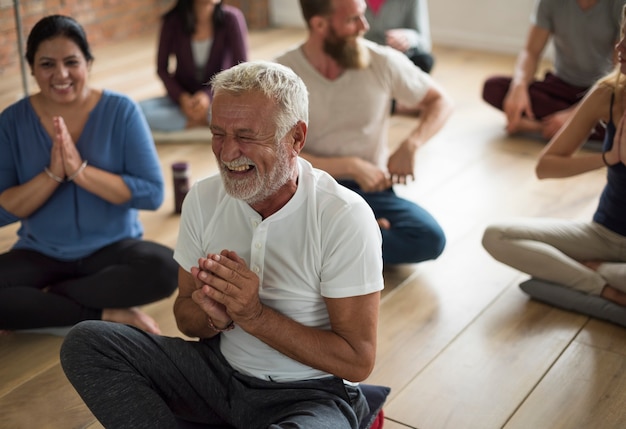 Uomo anziano felice in una lezione di yoga