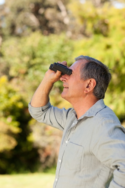 Uomo anziano guardando il cielo con il suo binocolo