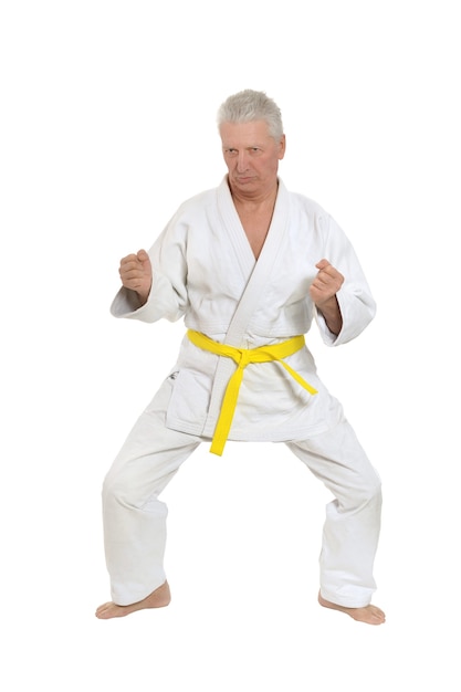 Uomo anziano in posa di karate su sfondo bianco