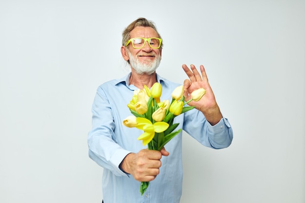 Uomo anziano in una camicia blu con un mazzo di fiori vista ritagliata