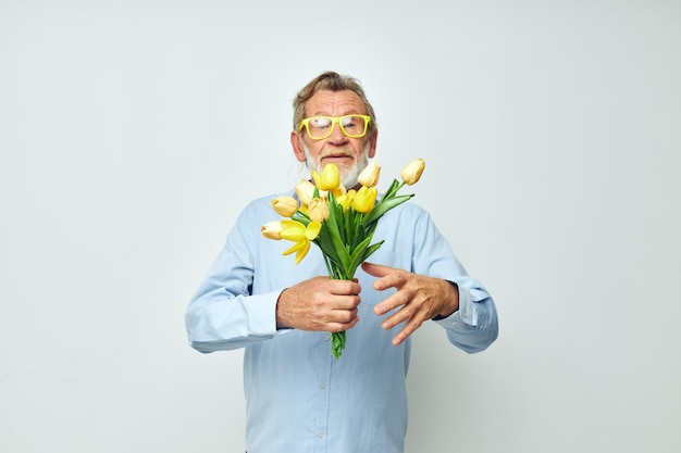 Uomo anziano in una camicia blu con un mazzo di fiori vista ritagliata
