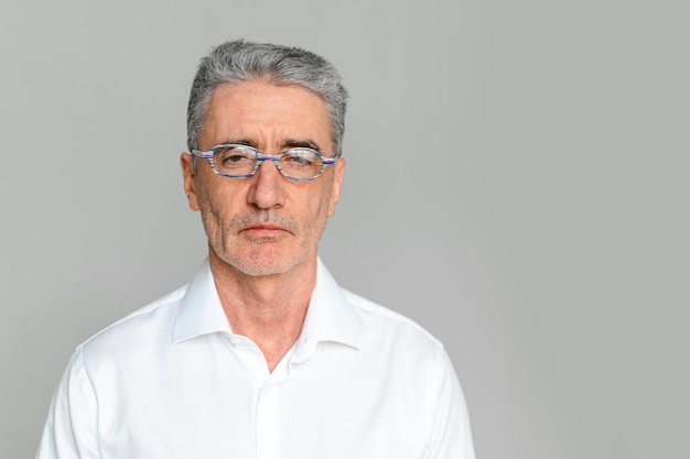 Uomo anziano o anziano che indossa occhiali ottici su sfondo grigio Spazio di copia Oftalmologia