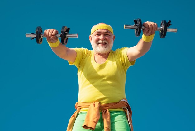 Uomo anziano sollevamento pesi uomo anziano in palestra lavorando con i pesi uomo anziano felice con manubri