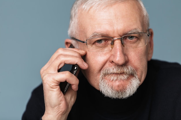 Uomo anziano utilizzando il ritratto del telefono