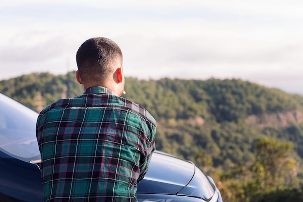 Uomo appoggiato al suo camper osservando la natura