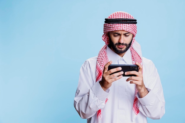Uomo arabo che gioca a uno smartphone