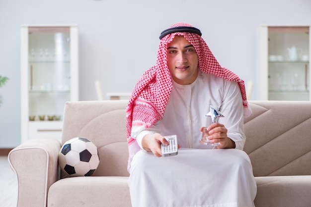 Uomo arabo che guarda il calcio di sport alla tv