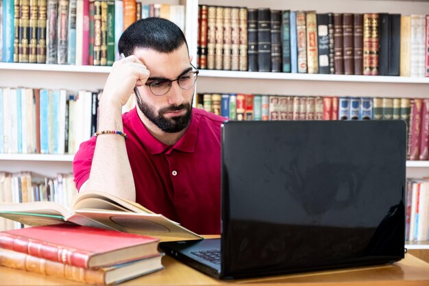 Uomo arabo che usa un laptop durante conferenze o riunioni per studiare e insegnare attraverso i canali online