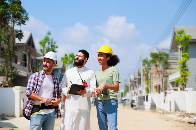 Uomo arabo e lavoro di squadra Donna e uomo professionisti Afroamericani persone di razza mista Operaio edile e imprenditore che lavorano su computer tablet digitale in cantiere