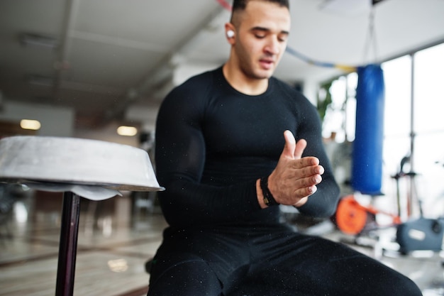 Uomo arabo muscolare che si allena in palestra moderna.