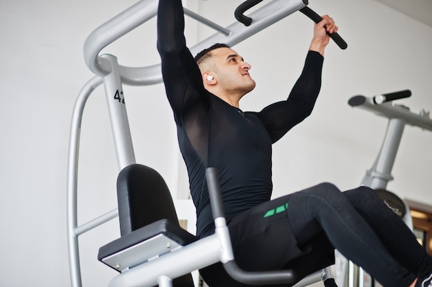 Uomo arabo muscoloso allenamento nella moderna palestra.