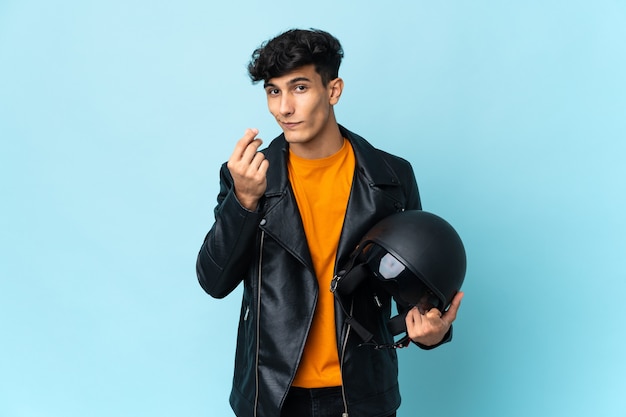 Uomo argentino con un casco da motociclista che fa un gesto di denaro