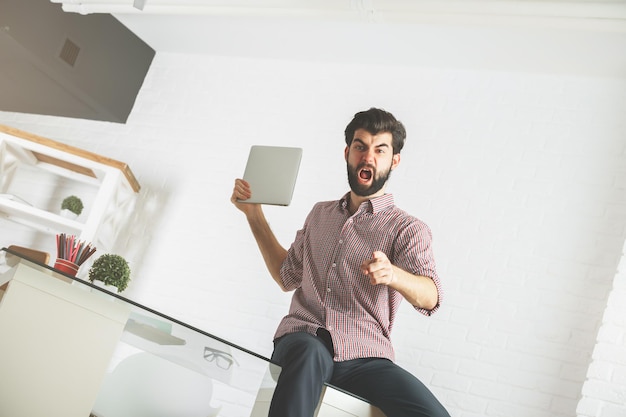 Uomo arrabbiato che rompe il computer portatile