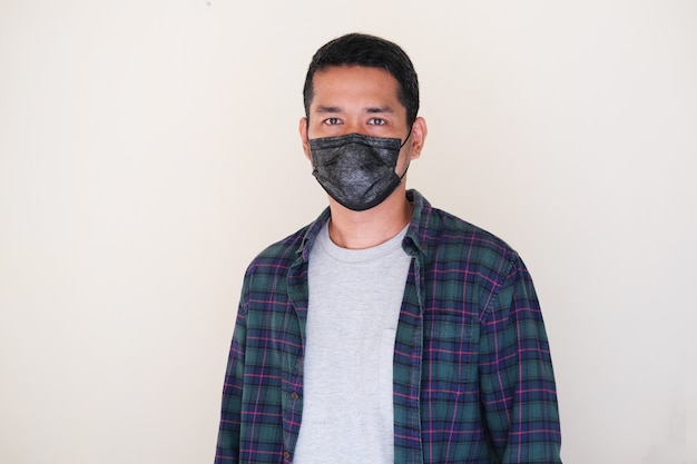 Uomo asiatico adulto che indossa una maschera medica nera