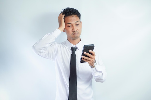 Uomo asiatico adulto che mostra un'espressione di stress quando risponde a una telefonata