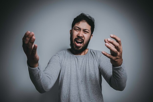 Uomo asiatico bello arrabbiato su sfondo bianco Ritratto di giovane concetto maschile di stress