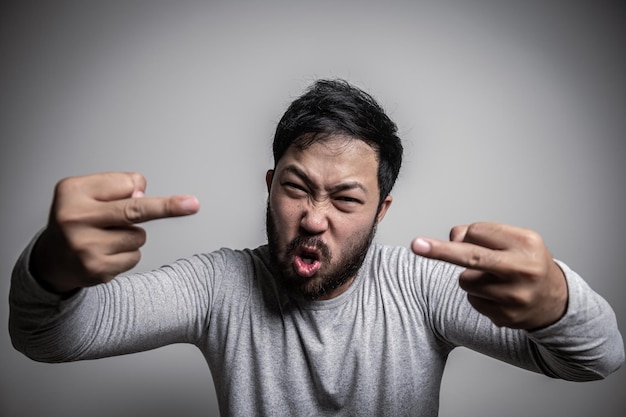 Uomo asiatico bello arrabbiato su sfondo bianco Ritratto di giovane Concetto maschile di stress