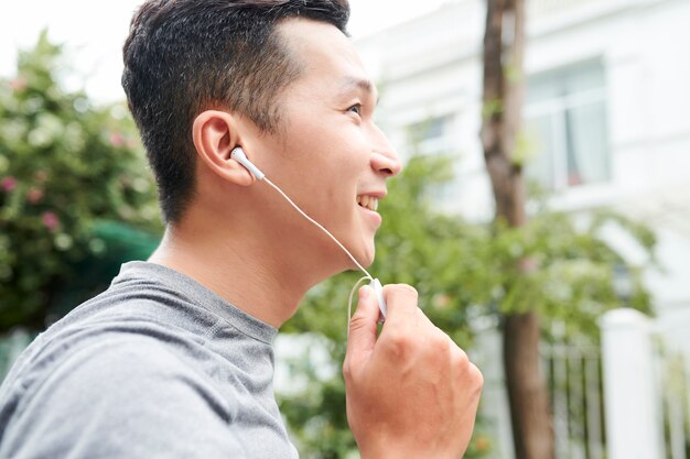 Uomo asiatico che ascolta il musi