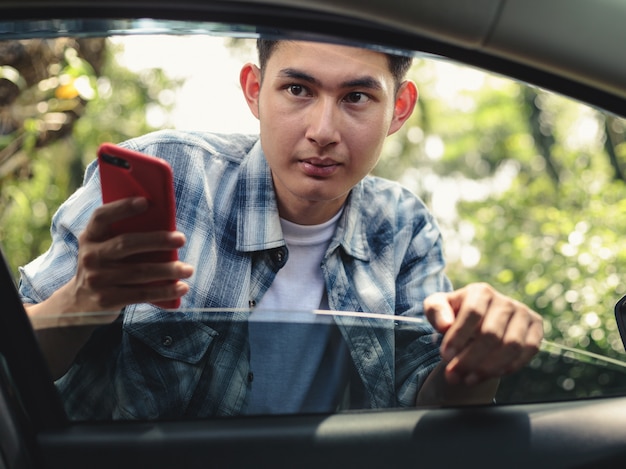 Uomo asiatico che aspetta taxi di Uber