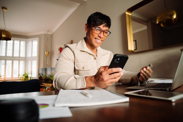 Uomo asiatico che compra online con carta di credito