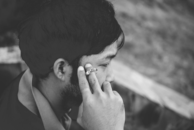 Uomo asiatico che fuma e pensa ai problemi della vita