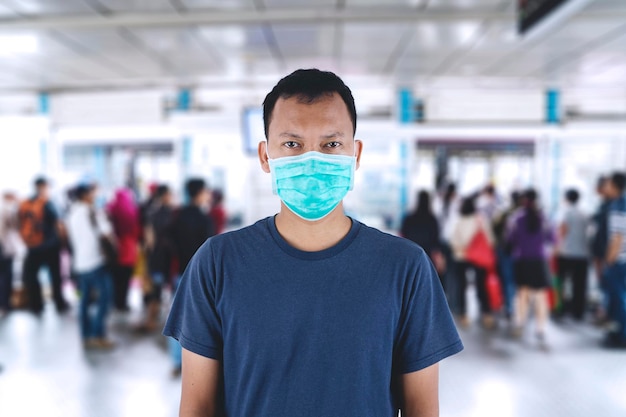 Uomo asiatico che indossa una maschera mediale in stazione