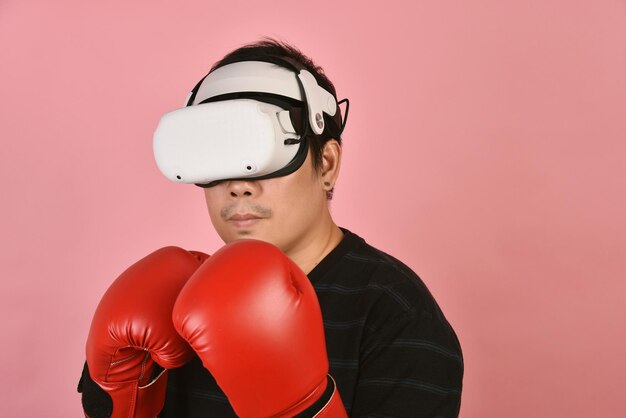 Uomo asiatico che usa gli occhiali vr Allenarsi con l'applicazione di videogiochi di boxe dall'auricolare per realtà virtuale Il giovane gode di una nuova esperienza di fitness con la tecnologia vr Studio girato