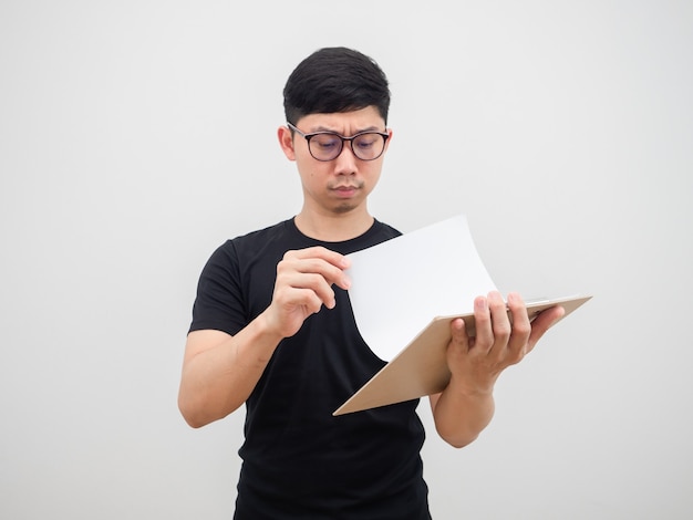 Uomo asiatico con gli occhiali che controlla la scheda del documento in mano faccia seria su sfondo bianco