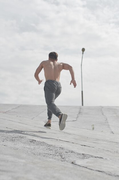 Uomo asiatico dell'atleta che pareggia la mattina all'aperto, stile della foto di minimalismo del corridore kazako