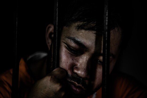 Uomo asiatico disperato nel concetto di prigioniero di ferropopolo della TailandiaSpero di essere liberoPrigionieri seri imprigionati nella prigione