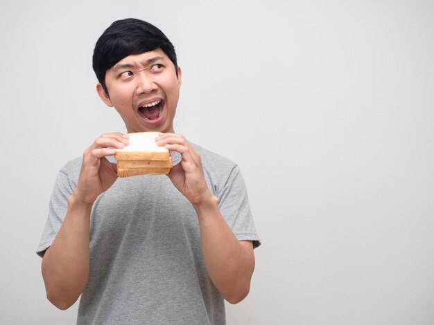 Uomo asiatico molto affamato che mangia panino guardando il ritratto dello spazio della copia