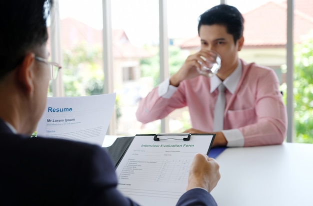 Uomo asiatico nell'intervista di lavoro all'ufficio, giovane uomo asiatico di affari mentre intervista per assunzione di lavoro, ricerca di lavoro, affare