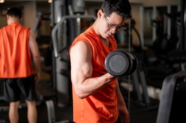 Uomo asiatico sta lavorando in palestra