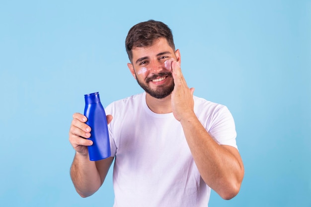 Uomo attento che applica crema corpo e viso per idratare la pelle