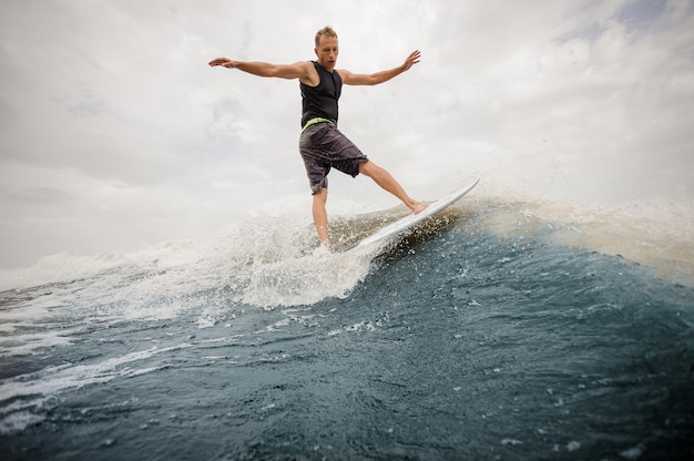 Uomo attivo di retrovisione che guida sul wakeboard