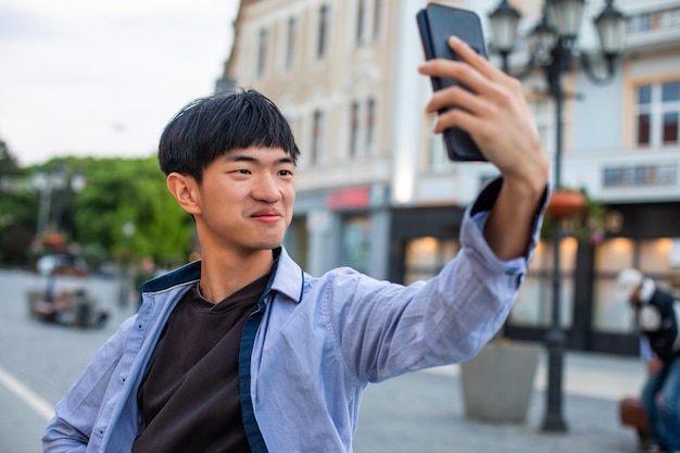 Uomo attraente che prende selfie sulla piazza della città europea