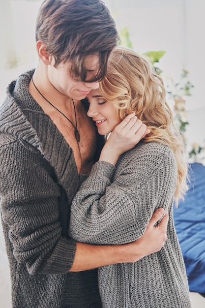 Uomo attraente e donna in camera da letto insieme coccole carino